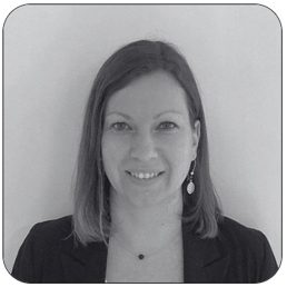 Portrait en noir et blanc de Sophie Plusquellec, responsable administrative de PCR Group : femme aux cheveux mi-longs châtains, boucles d’oreilles pendantes, veste noire, large sourire